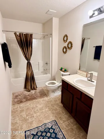 a bedroom with a bed a chandelier and a window