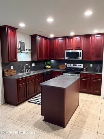 a kitchen with a stove sink and cabinets
