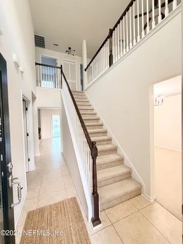 a view of staircase with railing and white walls
