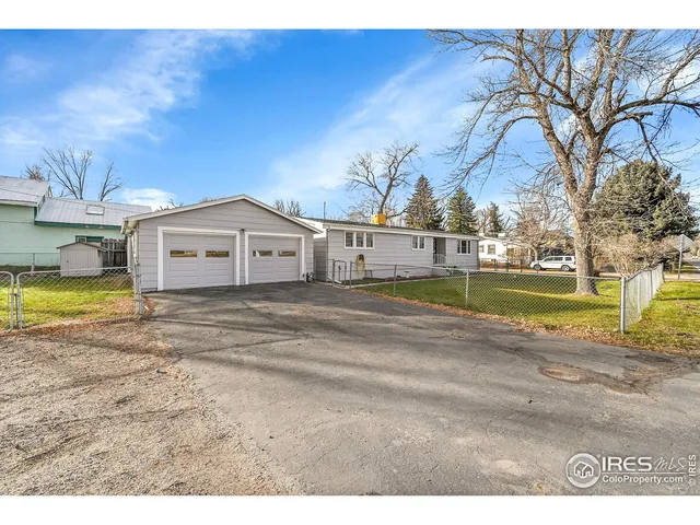 a view of a house with a big yard and large trees