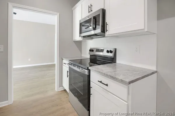 a kitchen with stainless steel appliances granite countertop a sink and a microwave