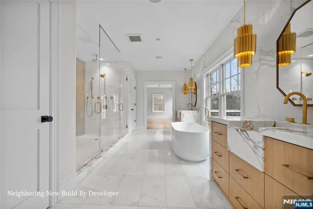 a bathroom with a granite countertop sink a toilet a mirror and shower