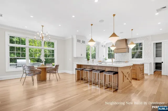 a kitchen with stainless steel appliances granite countertop a stove a kitchen island a dining table and chairs