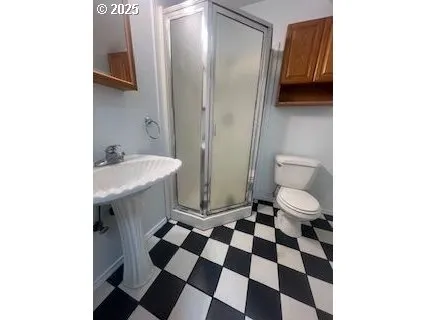 a bathroom with a sink a toilet a shower and a mirror
