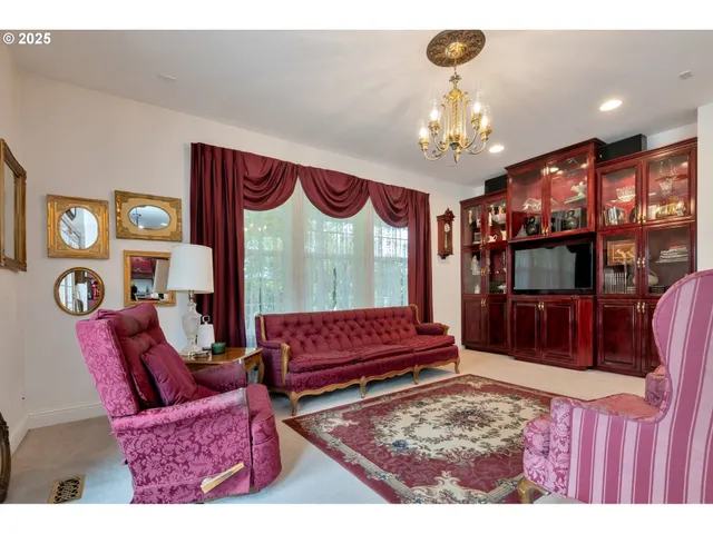 a living room with furniture a chandelier and a flat screen tv