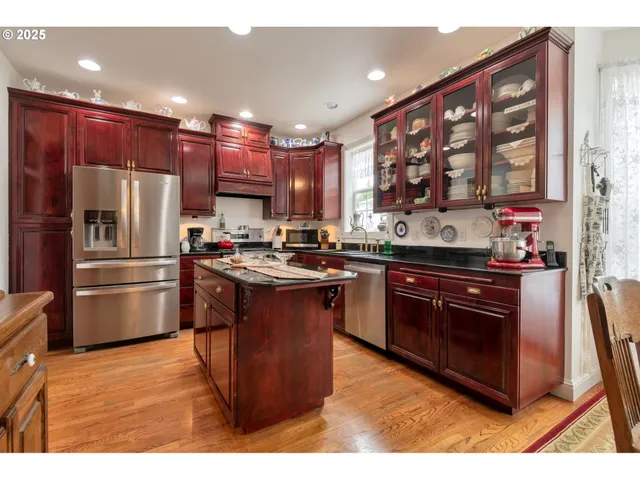 a kitchen with stainless steel appliances granite countertop a stove a sink dishwasher a refrigerator and a oven