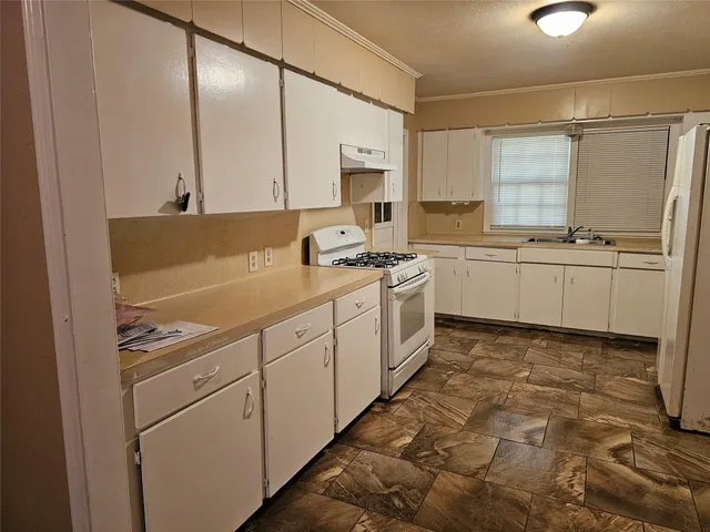 a kitchen with a sink stove and cabinets