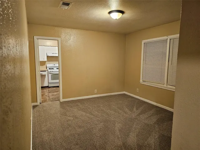 an empty room with windows and cabinet