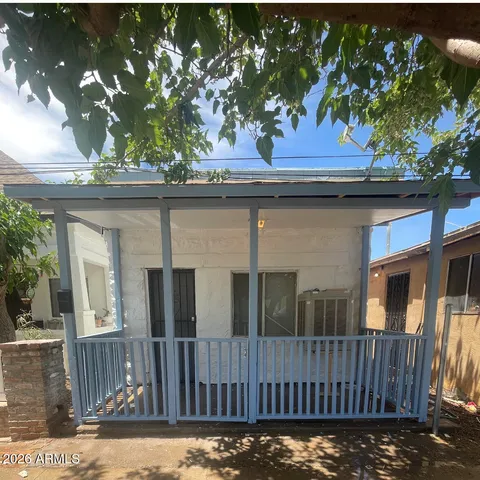 a view of a house with a small yard and wooden fence