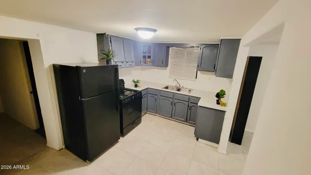 a kitchen with a refrigerator a sink and cabinets