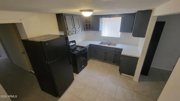 a kitchen with cabinets and a refrigerator