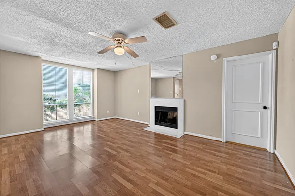 a view of a livingroom with wooden floor and a ceiling fan