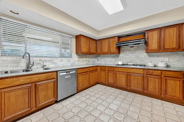 a kitchen with stainless steel appliances granite countertop a sink and cabinets