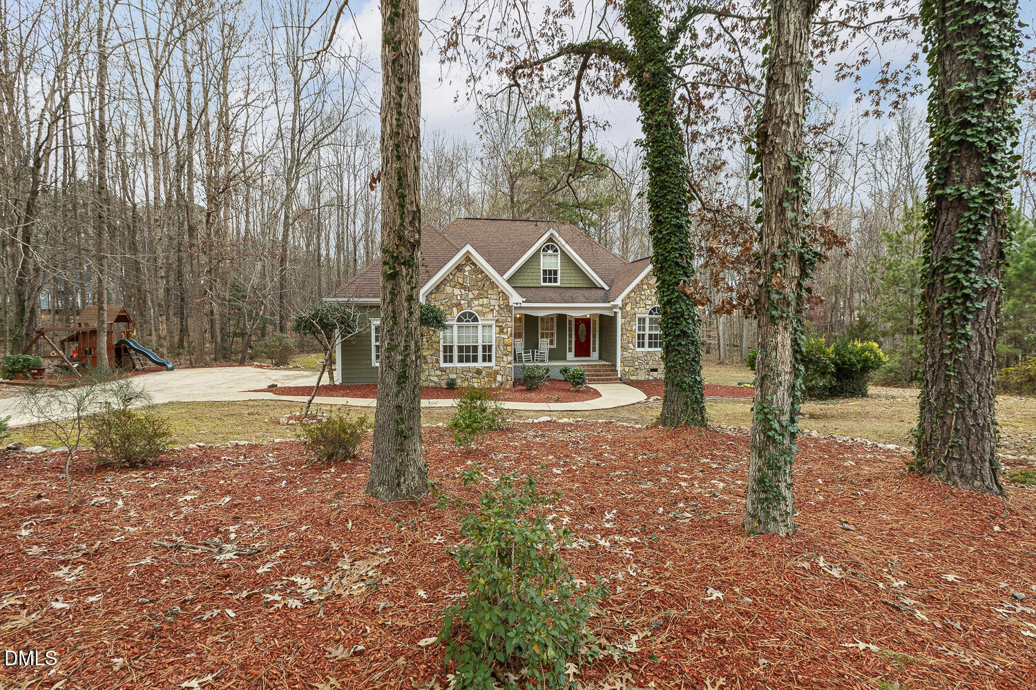 a front view of a house with a yard and large trees