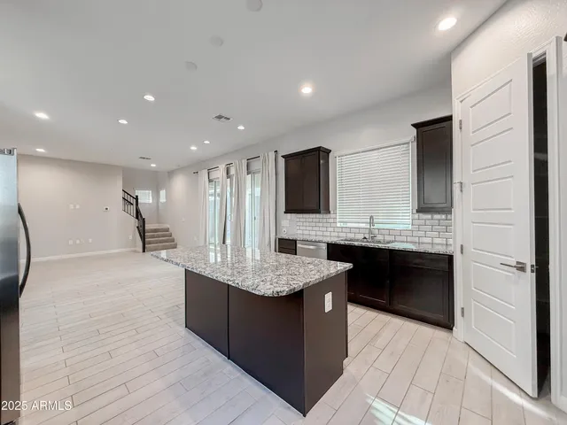 a large kitchen with a large counter top stainless steel appliances and cabinets
