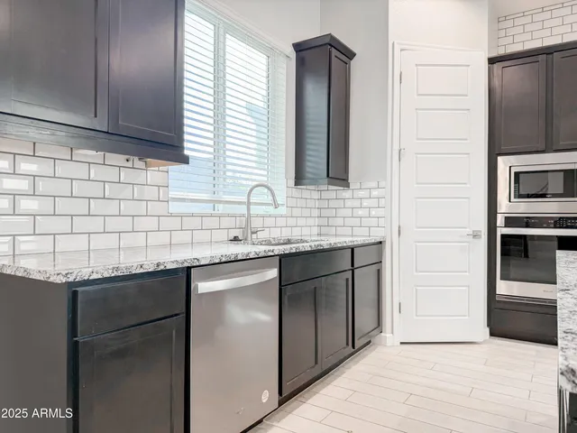 a kitchen with stainless steel appliances granite countertop a sink and a microwave