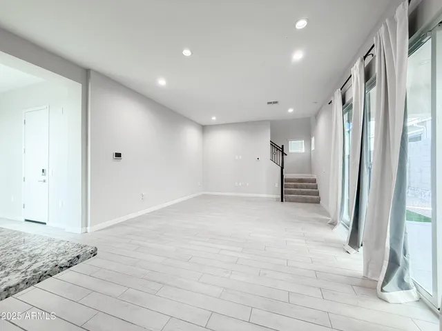 a view of a hallway with wooden floor and a refrigerator