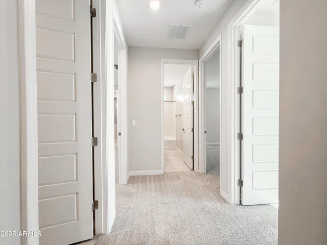 a view of a hallway with closet and bathroom