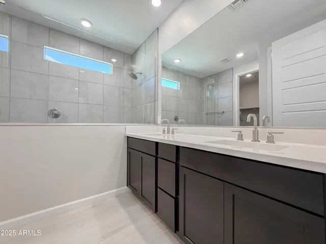 a bathroom with a sink a large mirror and a bathtub