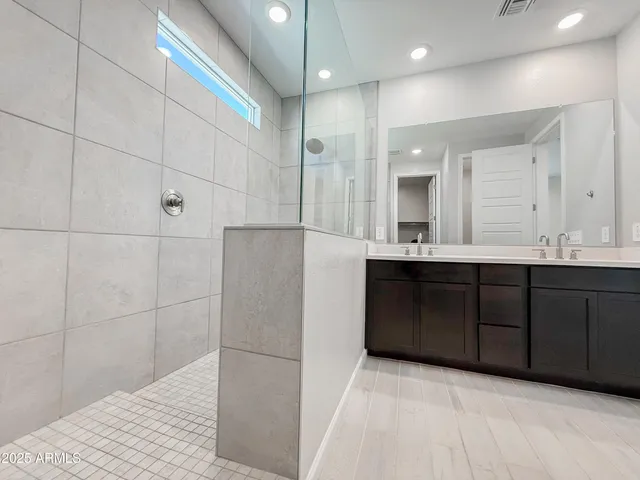 a bathroom with a double vanity sink a mirror and shower