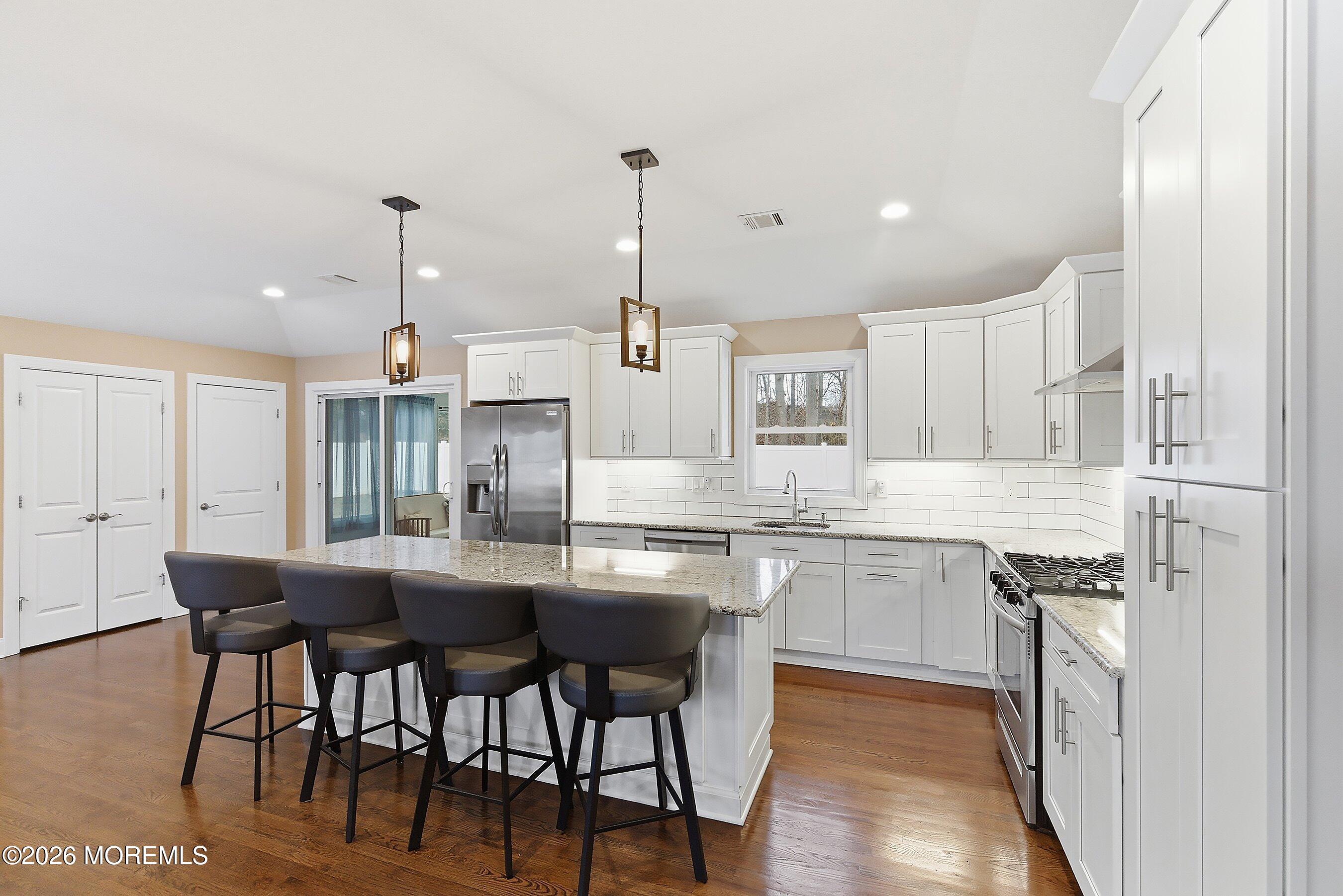 749 Hardean Road Brick, NJ 08724 - Photo 14 of 22 a kitchen with stainless steel appliances kitchen island granite countertop a table chairs sink and cabinets