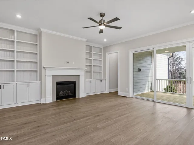 a view of an empty room with a fireplace and a window