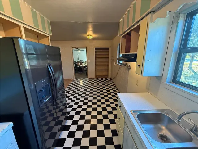 a kitchen with a sink a refrigerator and cabinets