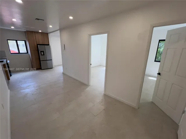 an empty room with staircase and mirror