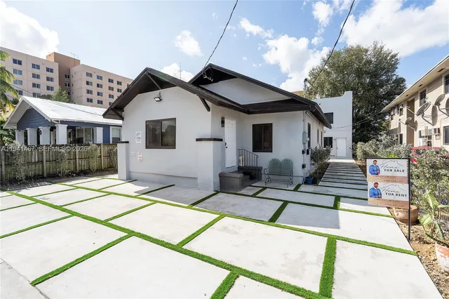 a view of a white building among the street with palm trees