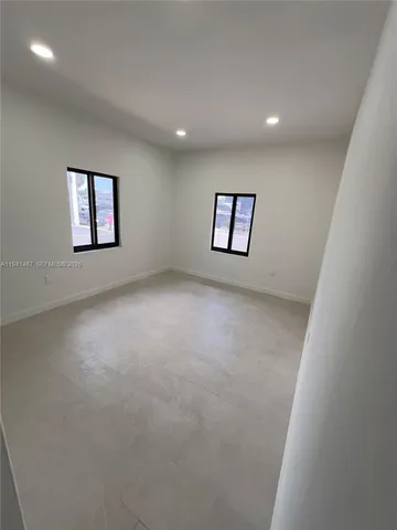 an empty room with windows and closet