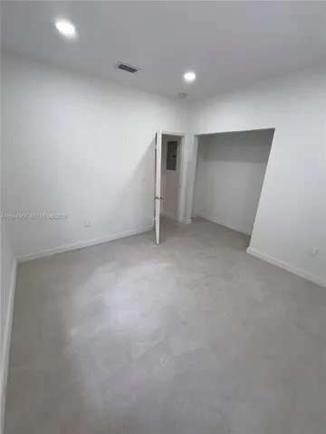 an empty room with closet and windows