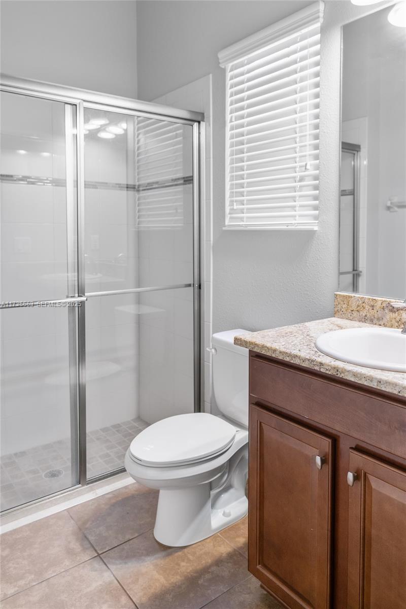 11436 Drifting Leaf Drive Riverview, FL 33579 - Photo 14 of 21 a bathroom with a granite countertop toilet a sink a mirror and shower