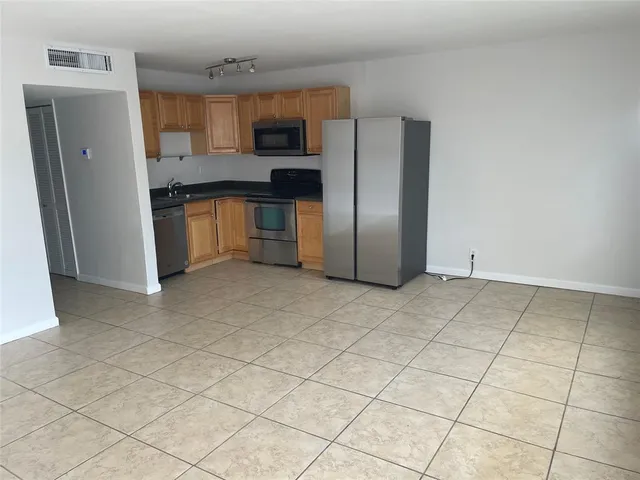 a kitchen with stainless steel appliances a refrigerator sink and cabinets
