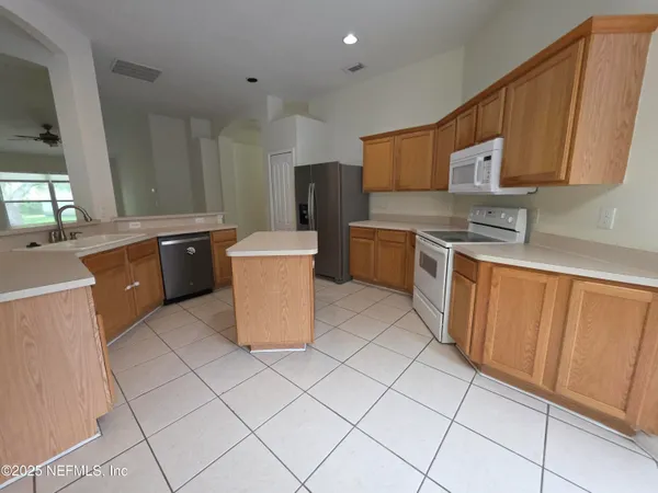 a kitchen with stainless steel appliances granite countertop a stove refrigerator sink and cabinets