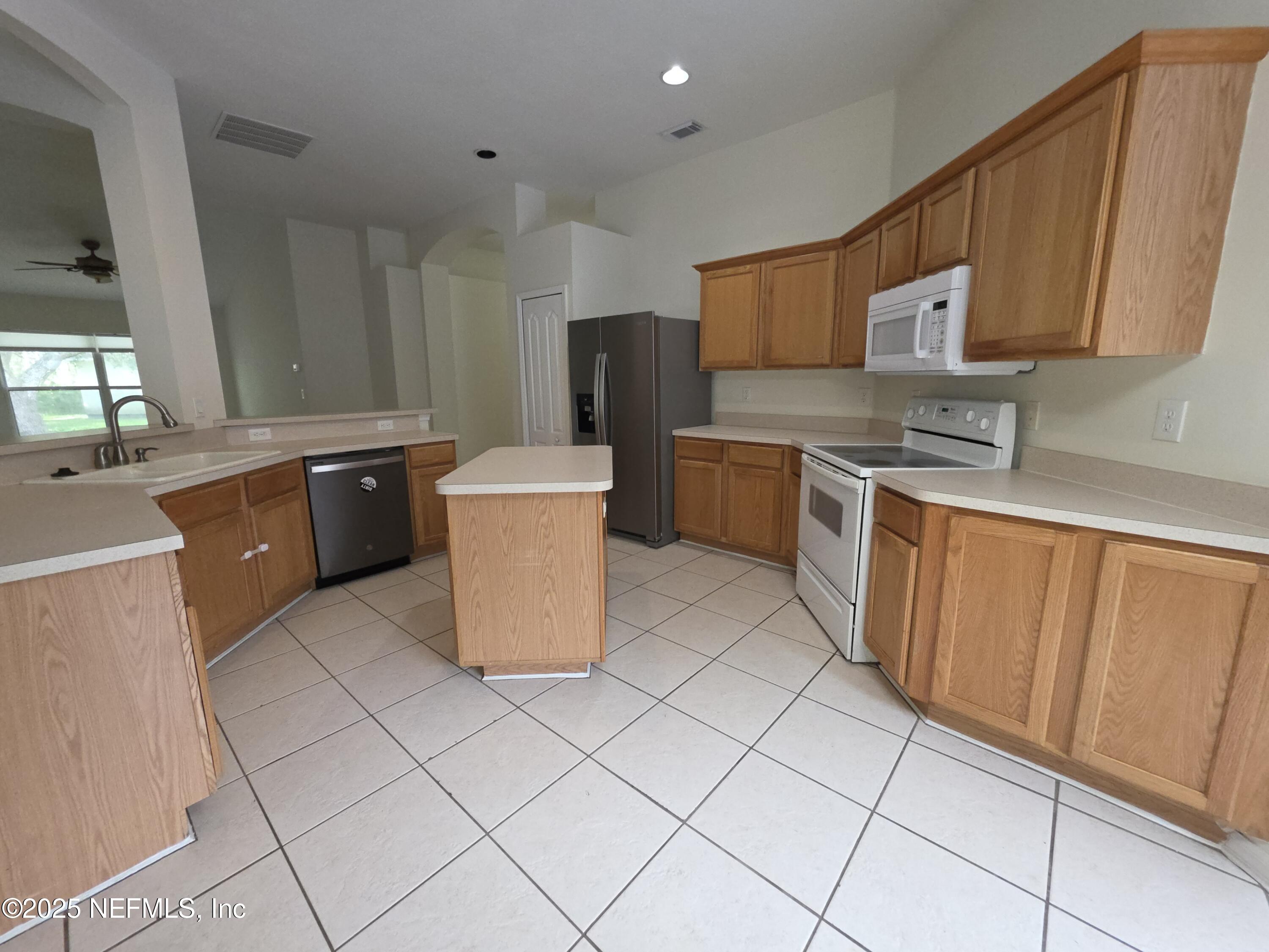 1713 Austin Lane St. Augustine, FL 32092 - Photo 4 of 12 a kitchen with stainless steel appliances granite countertop a stove refrigerator sink and cabinets