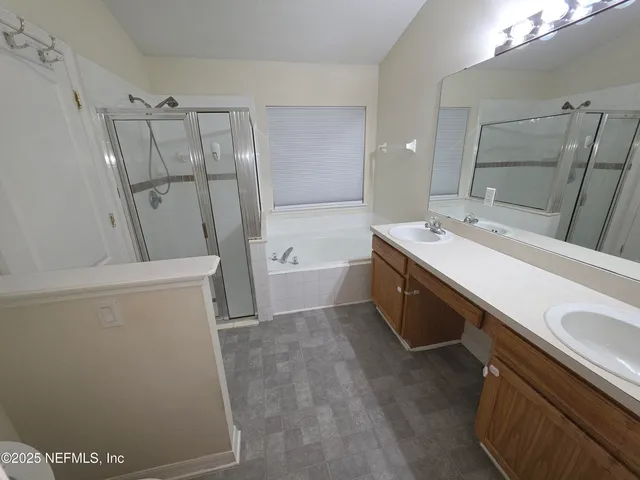 a bathroom with a double vanity sink toilet and tub