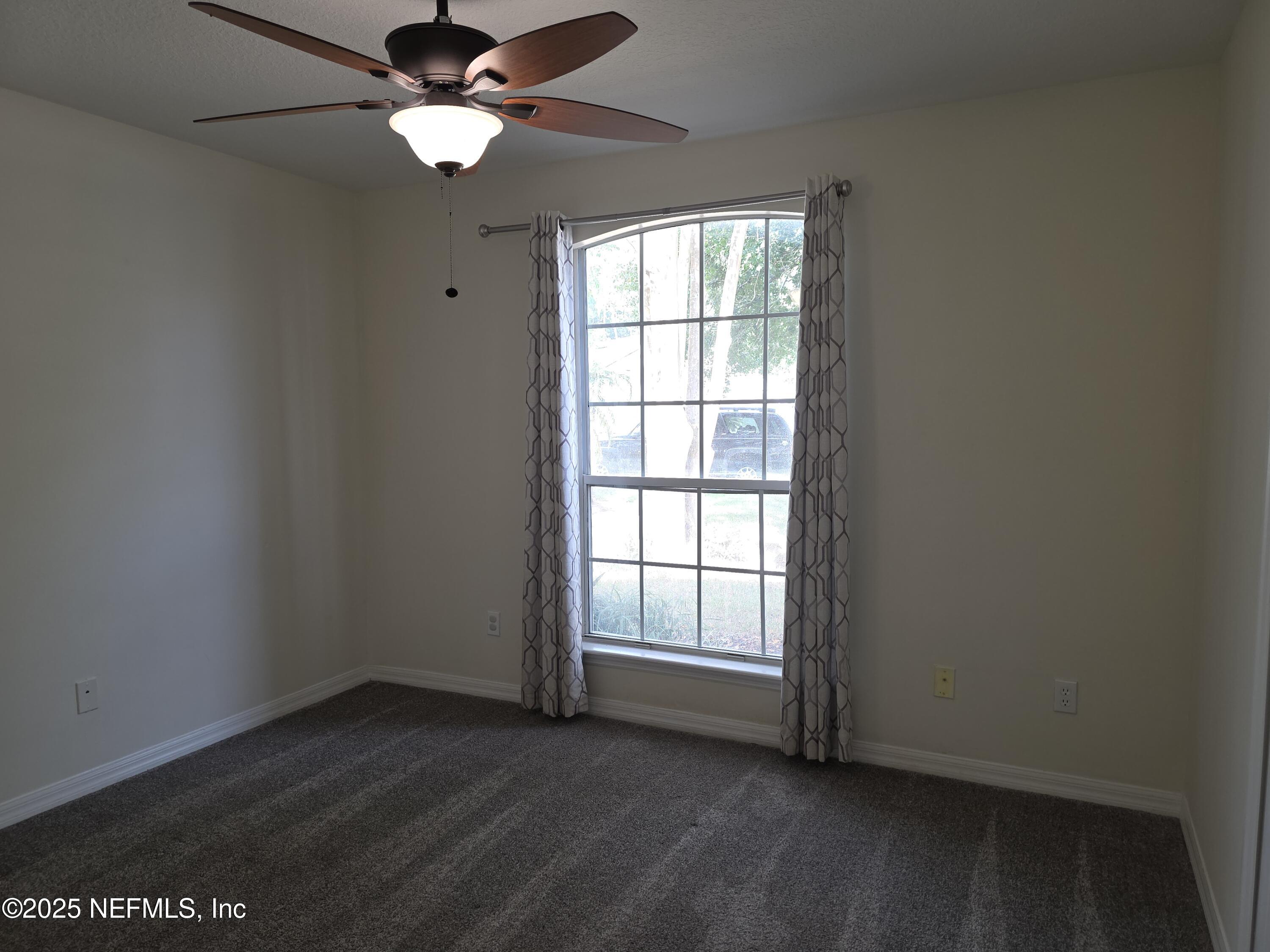 1713 Austin Lane St. Augustine, FL 32092 - Photo 10 of 12 an empty room with wooden floor fan and windows