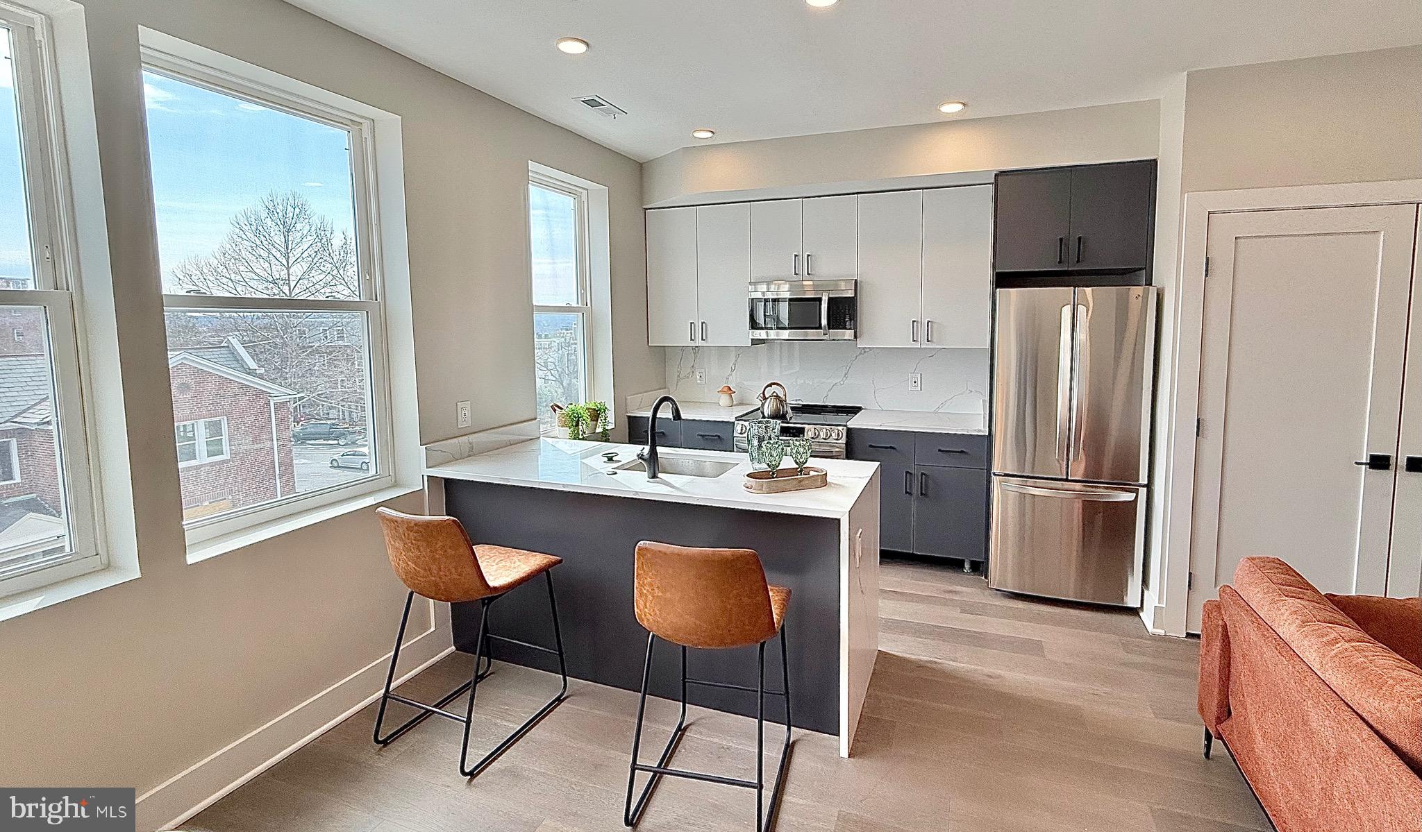 1004 18th Street Northeast, Unit 6 Washington, DC 20002 - Photo 5 of 9 a kitchen with stainless steel appliances granite countertop a refrigerator a sink a stove a dining table and chairs