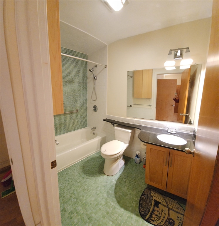 24 Bay State Road, Unit 11 Cambridge, MA 02138 - Photo 17 of 26 a bathroom with a granite countertop toilet a sink and a bathtub