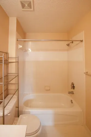 an empty room with a window and a chandelier fan