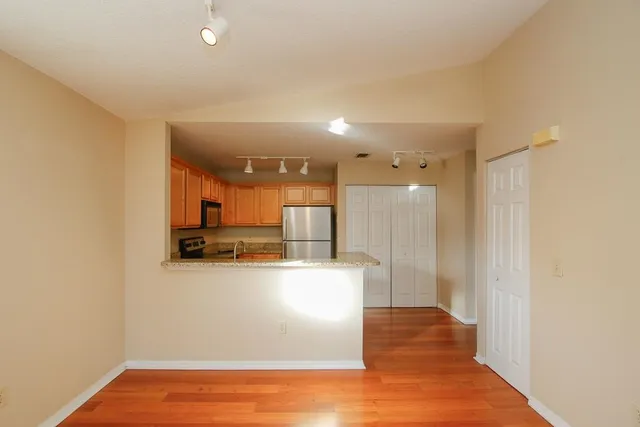 a kitchen with stainless steel appliances granite countertop a refrigerator a stove a sink and a microwave