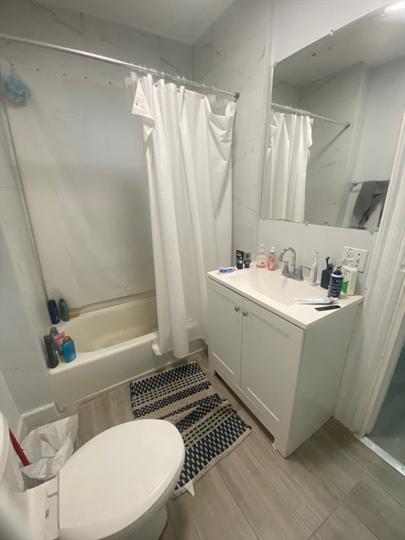 a bathroom with a sink a toilet a mirror and shower