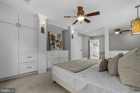 a spacious bedroom with a bed and a chandelier