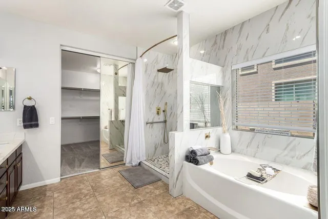 a bathroom with a tub a sink and a large mirror