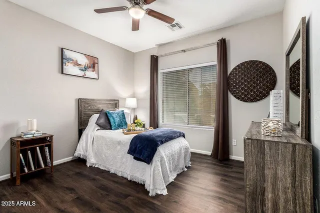 a bedroom with a bed two lamp and a large window