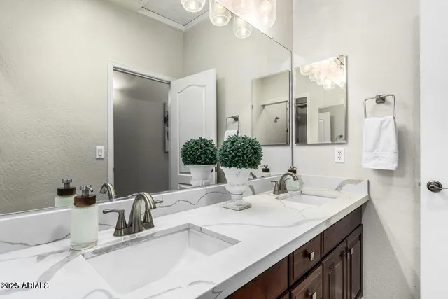 a bathroom with double vanity sinks and a mirror