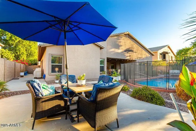 a patio view with a table and chairs under an umbrella