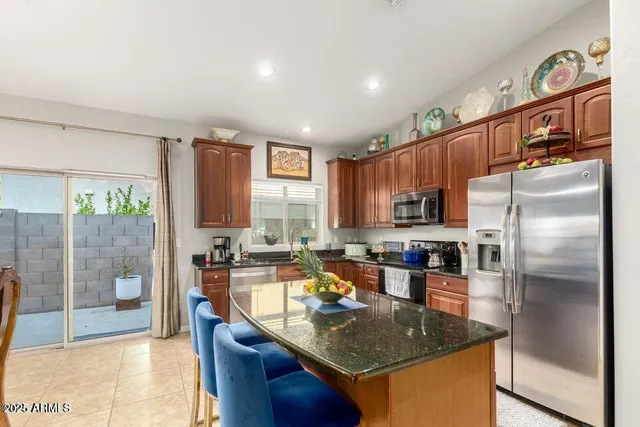 a kitchen with stainless steel appliances granite countertop a sink a stove and a refrigerator