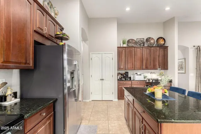 a kitchen with kitchen island granite countertop a sink a stove and a wooden cabinets