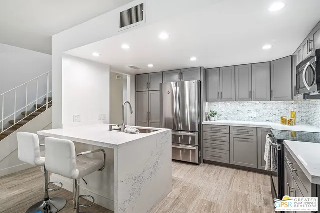 a kitchen with white cabinets and stainless steel appliances